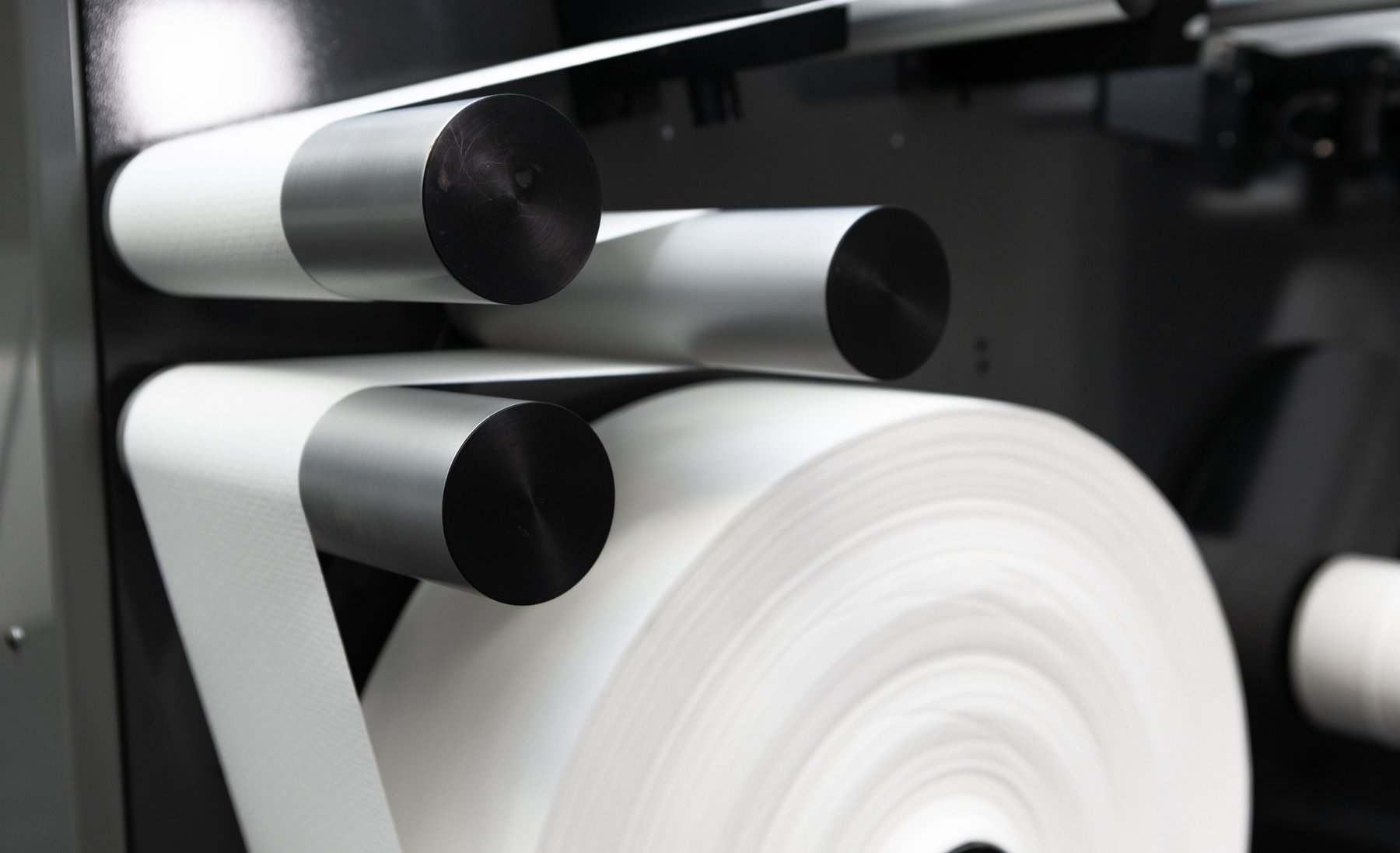 A large paper sample roll unwinding over the guide rolls of a Tapio Analyzer.