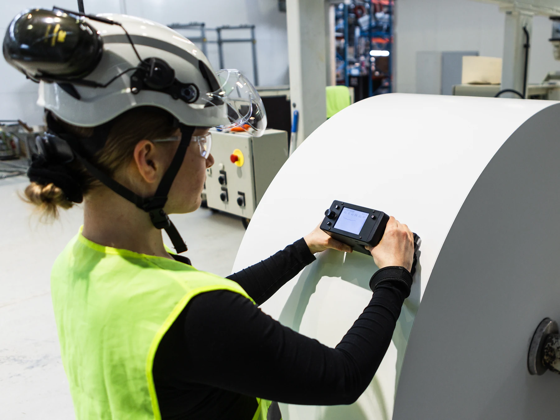 Tapio RQP Live pressed against a paper roll mounted in a machine while the operator checks the display.
