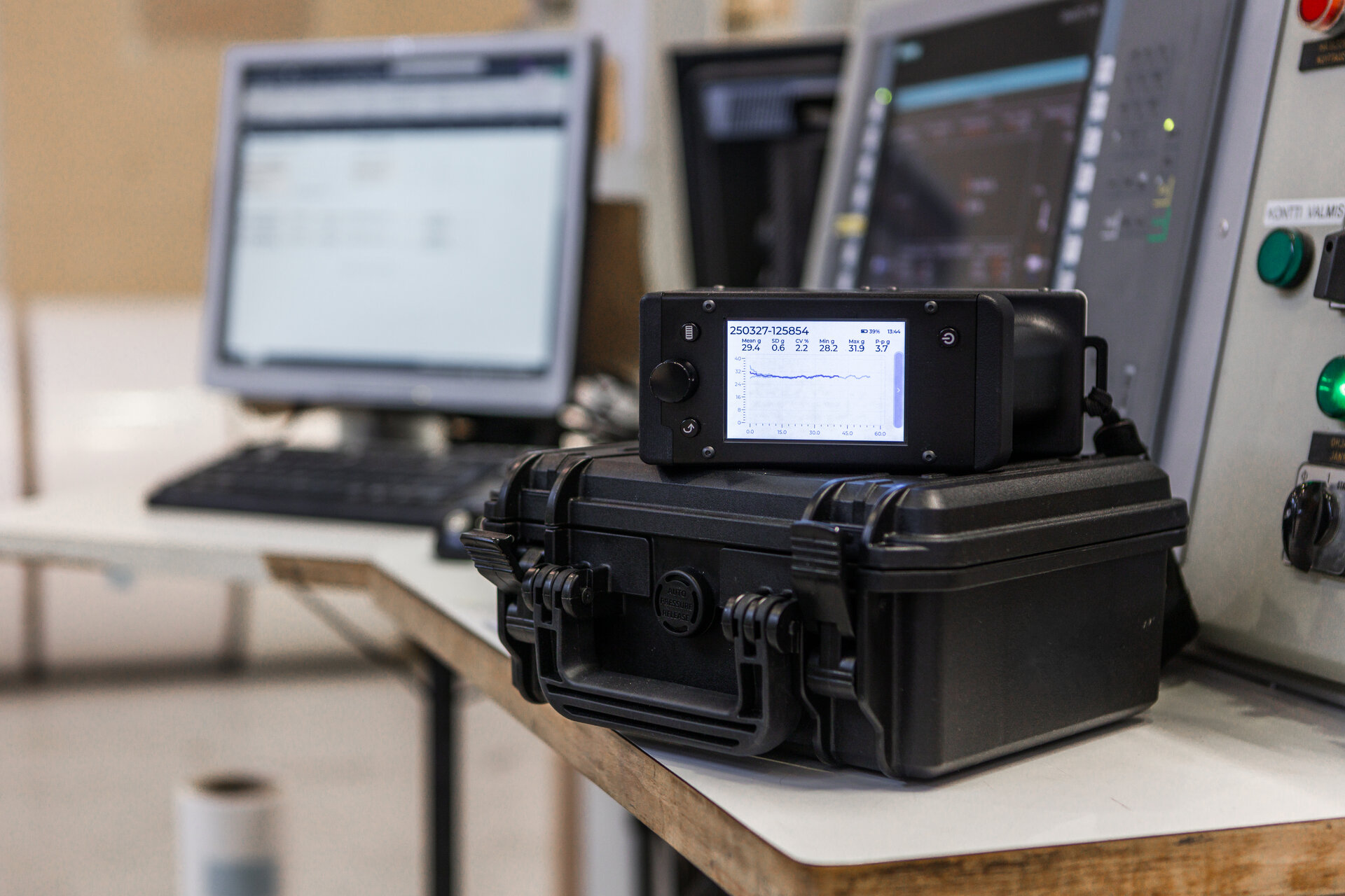 Tapio RQP Live handheld roll hardness profiler resting on a black rugged carrying case, displayed in an industrial or lab setting.