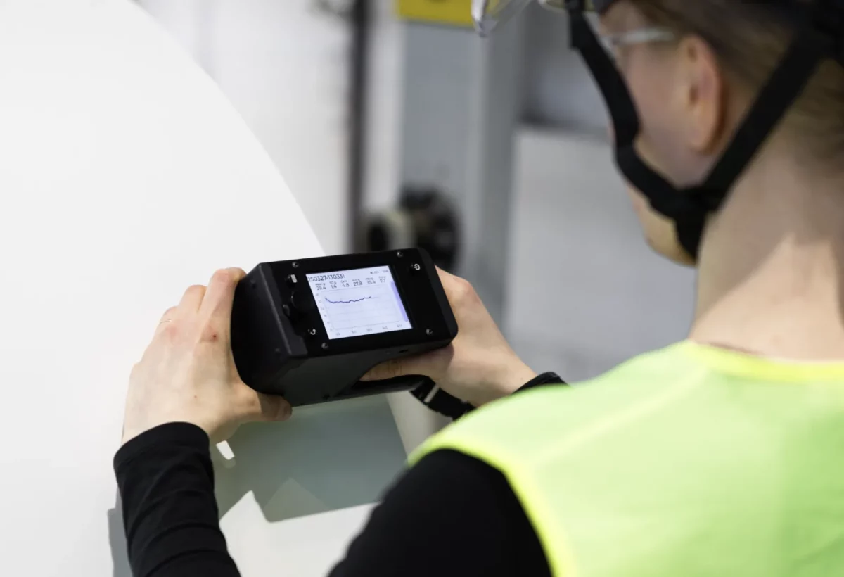 Operator using the Tapio RQP Live handheld roll hardness profiler on a large paper roll.